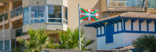 Ikurrina flag, a Basque symbol and the official flag of the Basque Country Autonomous Community of Spain and France, waving in front of a house in Arcachon photo