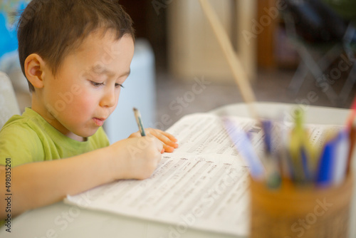 Tableau sur toile A little asian boy is doing solfeggio and music lessons