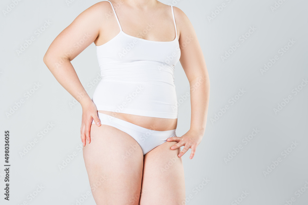 Woman with fat abdomen, overweight female body on gray background Woman with fat abdomen, overweight female body on gray background