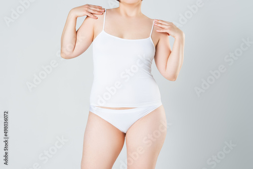 Woman in white underwear on gray background, not thin and not fat body shape