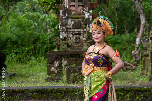 Portrait Balinese dancer woman at old temple with traditional peacock costume © Ace Mason
