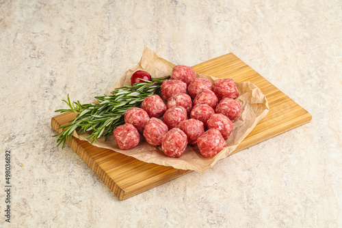 Raw uncooked beef meatballs served rosemary