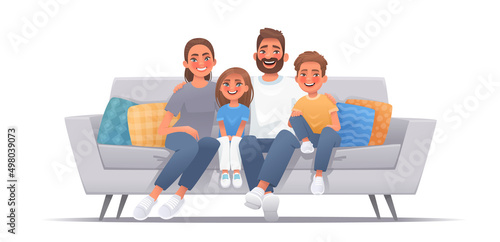 Happy family sitting on sofa over isolated background. Mom, dad, son and daughter are smiling while sitting on the couch. Concept of happiness and love, home comfort