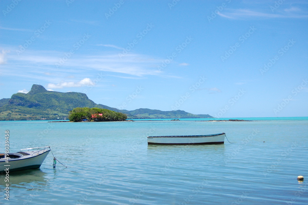 The waterfront of Mahebourg village in the south eastern coast of Mauritius in the Indian Ocean near Africa. A stunning view of the sea, the mountain with the fishing boats in the scenery. 