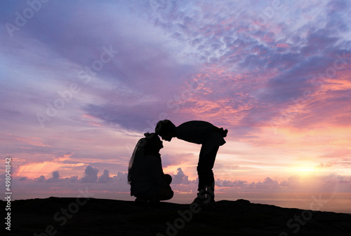 Silhouette of loving couple at sunrise. Love and romance concept.