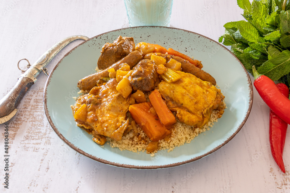 royal couscous in a plate on a table with a glass of milk royal couscous in a plate on a table with a glass of milk