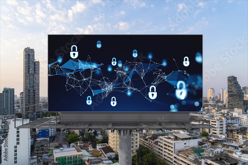 Padlock icon hologram on road billboard over panorama city view of Bangkok at sunset to protect business, Southeast Asia. The concept of information security shields.