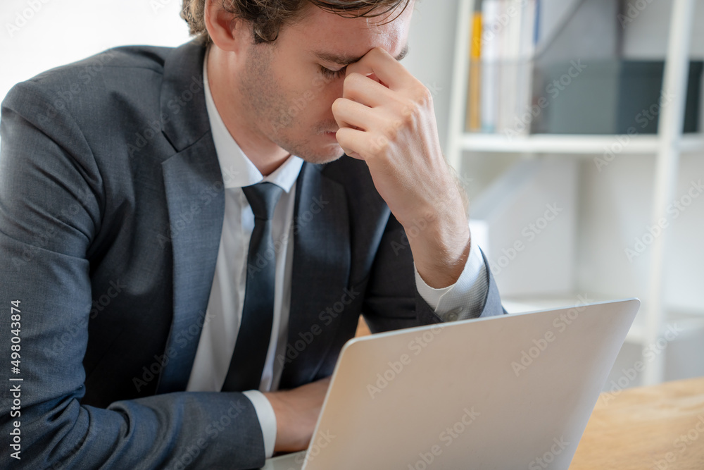 Young businessmen are tired and stressed from working by computer. Man has headache, eye strain, blurry vision, Migraine,office syndrome problem. Young businessmen are tired and stressed from working by computer. Man has headache, eye strain, blurry vision, Migraine,office syndrome problem.