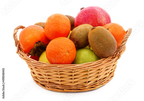 Tangerines, pomegranate and kiwi in a basket.
