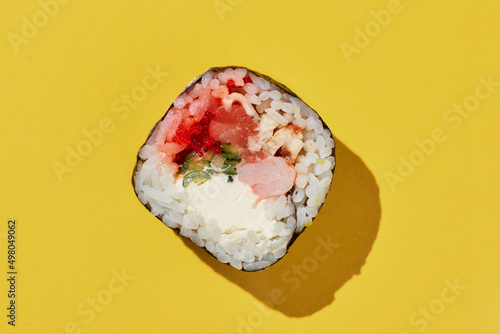 Fresh maki sushi roll on yellow background.