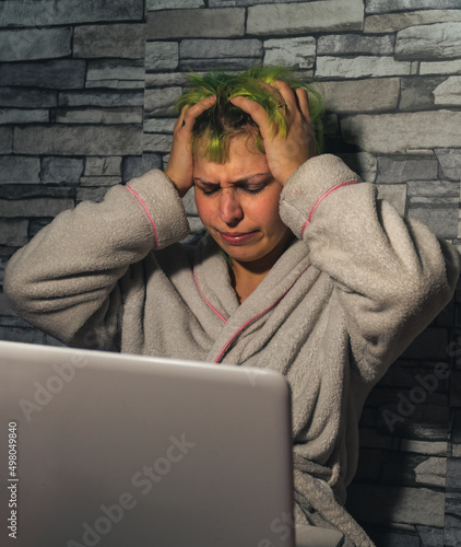Mujer estresada por el teletrabajo con las manos en la cabeza , mujer de pelo verde desesperada por el trabajo remoto, trabajando con pijama desde casa
