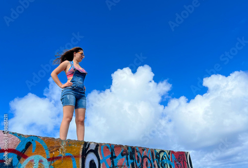 Portrait of young woman on the wall. woman above the clouds. in the background. Strong woman, Woman's victory and women's day concept