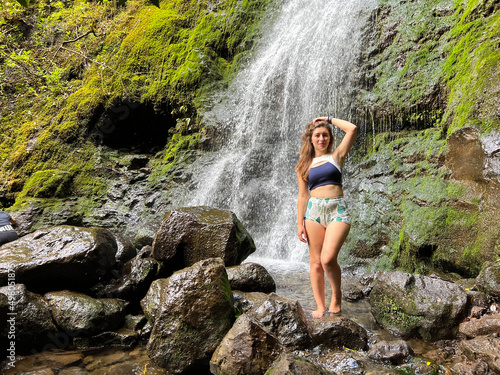 Portrait of young female tourist posing in front of Manoa Falls, Oahu, Hawaii, USA