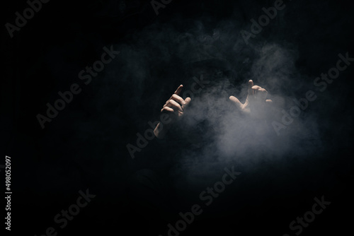 smoke clouds arround man with a hat on dark background