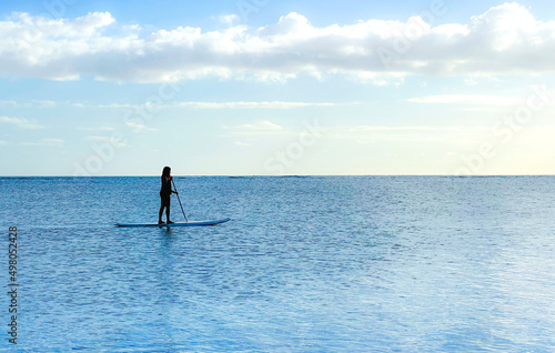 Young woman surfing alone in the ocean in Hawaii