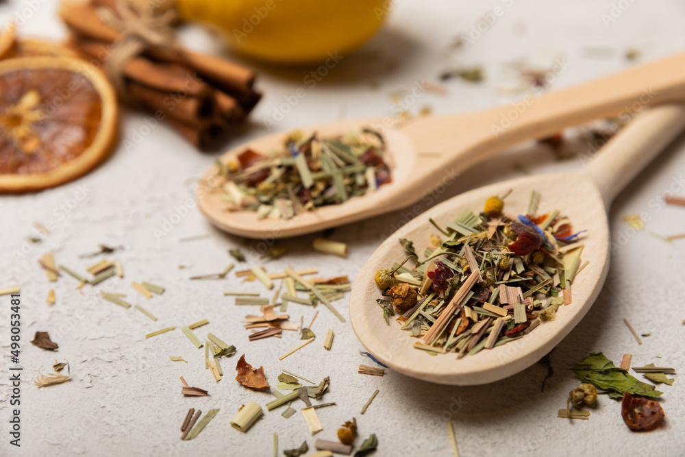 Wooden spoons with herbal tea leaves on a light background. Top view. Detox and immunity tea. Herbal collection of chamomile, mint, lemon balm. rosehip and pieces of dried fruits. Wooden spoons with herbal tea leaves on a light background. Top view. Detox and immunity tea. Herbal collection of chamomile, mint, lemon balm. rosehip and pieces of dried fruits.