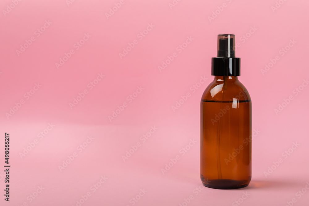 Skin care products in a glass jar. facial tonic. Composition on a pink background. Side view.Space for copy.