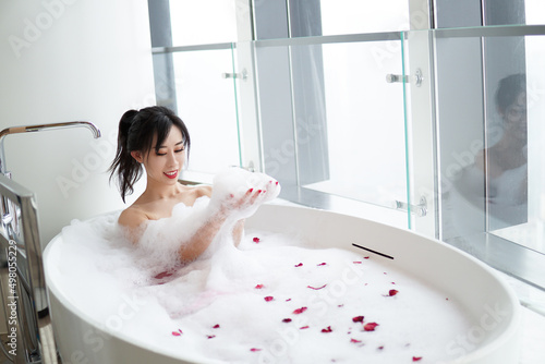 Young Asian woman relaxing in a bath.