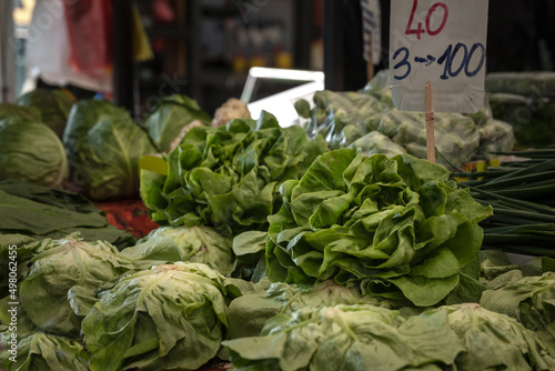 Selective blur on green lettuce salads for sale on Zeleni Venac market in Belgrade, Serbia with their price displayed. Lettuce is also called Lactuca sativa, a leaf vegetable used for salads. .. photo