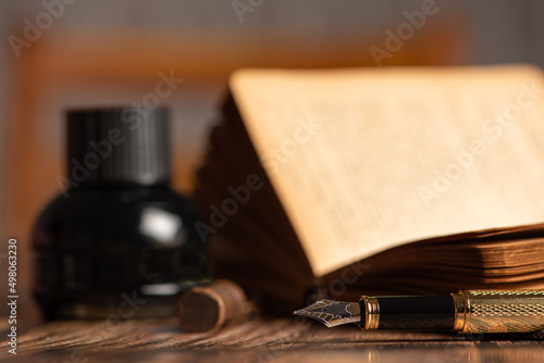 Fountain pen, beautiful fountain pen in an environment with an old clock, old book, ink among others, selective focus.