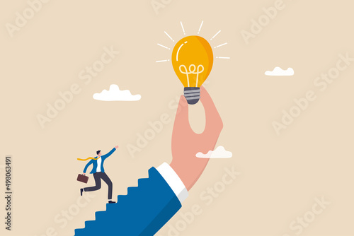 Inspiration idea to inspire or motivate people to success, business innovation or creativity, solution or invention concept, businessman step on stair of big hand holding inspiring bright lightbulb.