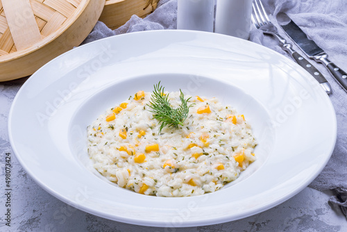 Risotto with pumpkin on plate on grey table