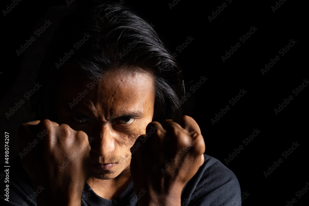 Man with anger expression looking for a fight. best for anger, mad, frustration, depression, and fighting background. lowkey photography technique with copy spa. Suitable for motivational background. Man with anger expression looking for a fight. best for anger, mad, frustration, depression, and fighting background. lowkey photography technique with copy spa. Suitable for motivational background.