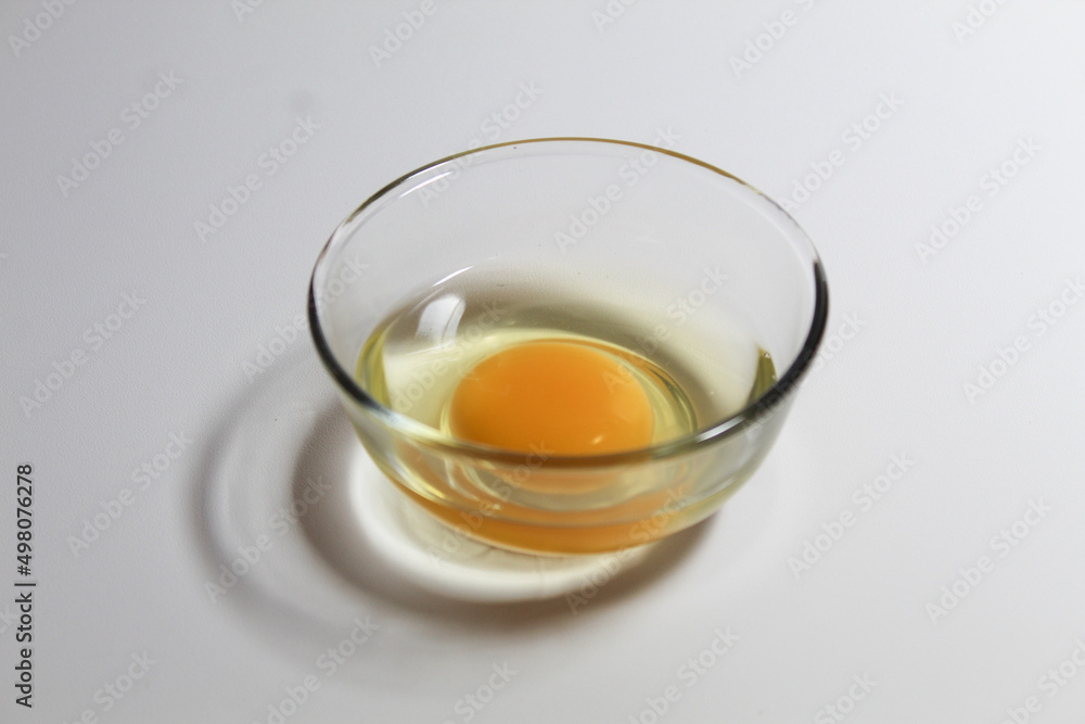 Raw egg in a glass bowl. Isolated on white background. Raw egg in a glass bowl. Isolated on white background.