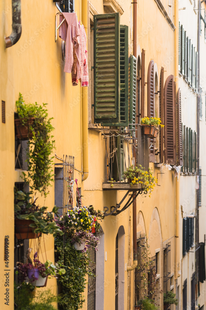 facade of yellow apartment building in Florence, Italy with clothes drying outside 