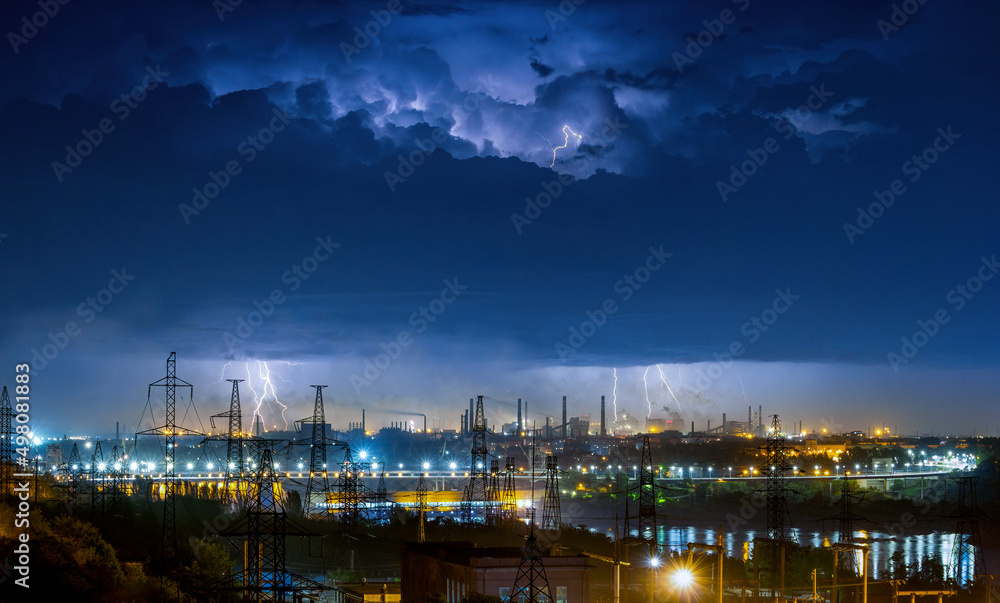 Spectacular industrial landscape with night thunderstorm, electric power lines and hydroelectric power plant in Zaporizhzhia, Ukraine