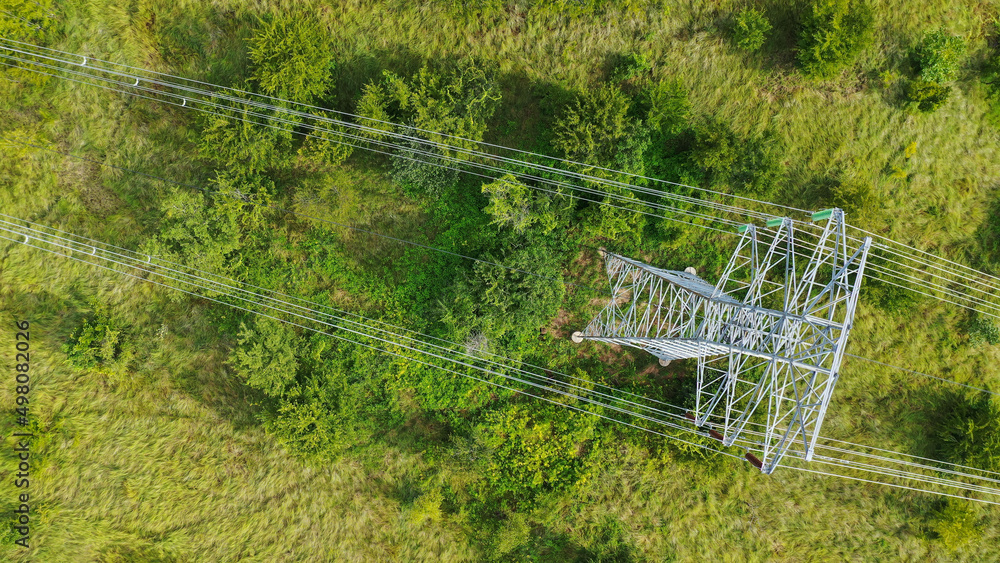 Aerial top down view high voltage steel power pylons in green field ...