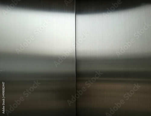 Stainless steel large sheet With light hitting the surface For background,Inside passenger elevator,Reflection of light on a shiny metal texture,stainless steel background.
