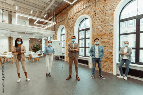 Creative business people in face masks looking at camera