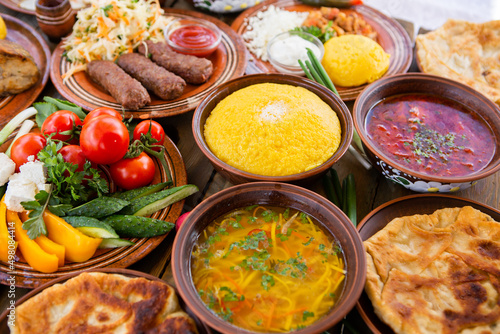 Homemade Romanian Food with 
pies, polenta, borscht, vegetables, fish, meat, stew, cheese and wine. Traditional dishes from Romania and the Republic of Moldova. photo