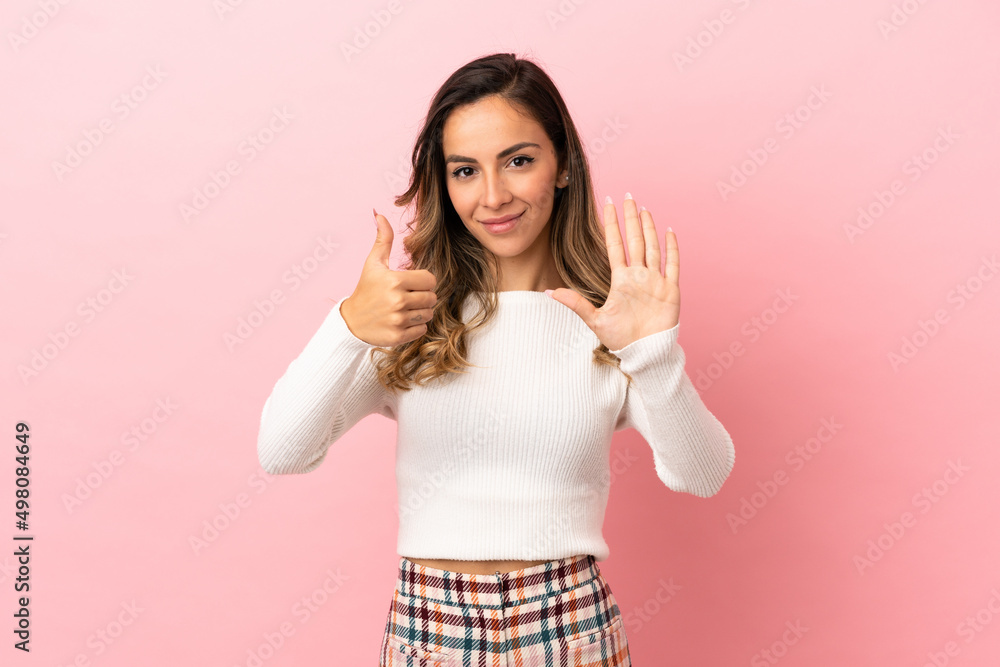 Young woman over isolated background counting six with fingers Young woman over isolated background counting six with fingers