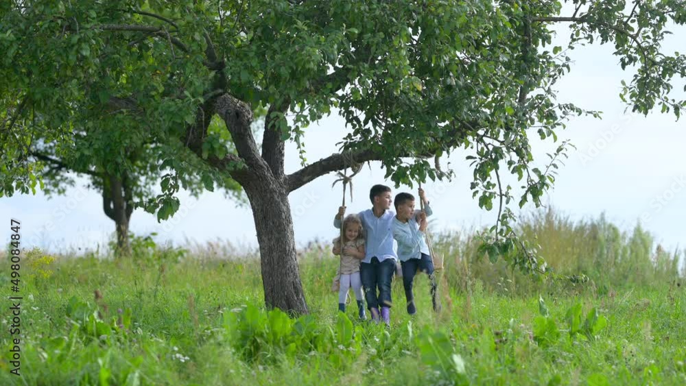 Lovely Children in the Evening Park swinging together. Happy childhood concept. Childhood moment. Lovely Children in the Evening Park swinging together. Happy childhood concept. Childhood moment.