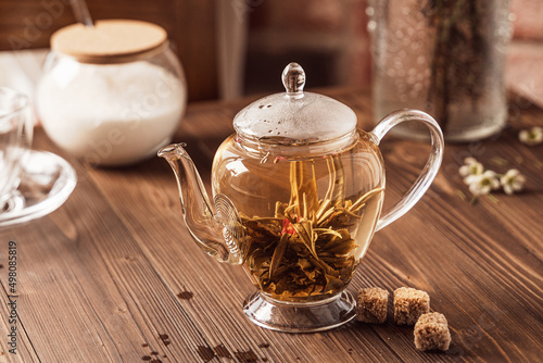 flower tea in a glass teapot on the wooden table