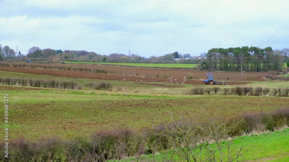 Tractor and chemical drum container on a trailer spraying the fields in preparation for spreading silage to be done prior to easter if weather perm Tractor and chemical drum container on a trailer spraying the fields in preparation for spreading silage to be done prior to easter if weather perm