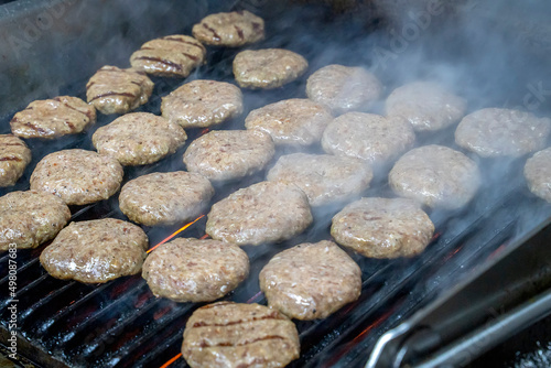 Grilled meatballs,tomatos ,peppers and mushrooms shown on a grill while cooking with somoke on them photo