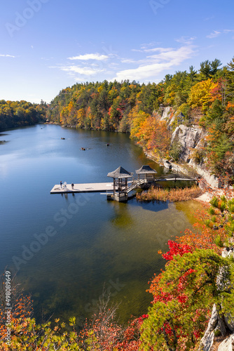 Foto Small fishing dock and gazebo on a peaceful lake, surrounded by colorful leaves and fall foliage