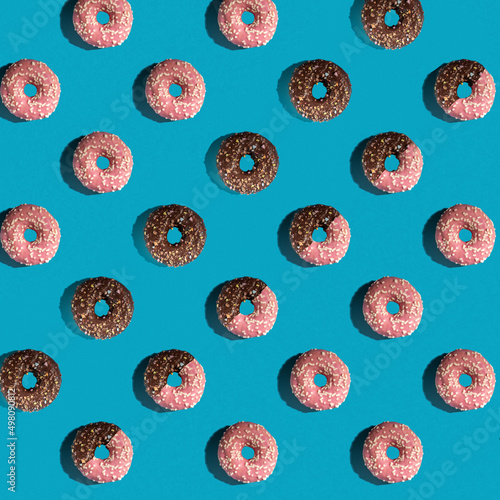 A pattern of delicious doughnuts on a blue background. Top view. Flat layer. Summer concept.