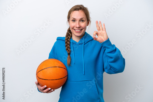Young caucasian woman playing basketball isolated on white background showing ok sign with fingers © luismolinero