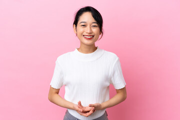 Young Vietnamese woman isolated on pink background laughing