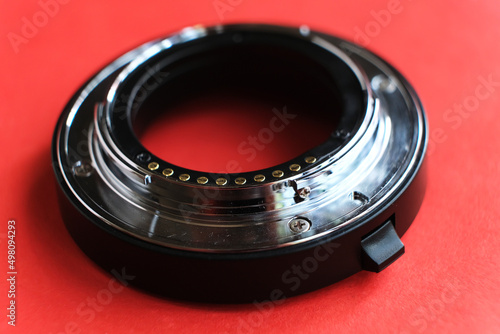 Close-up of camera lens adapter on red background