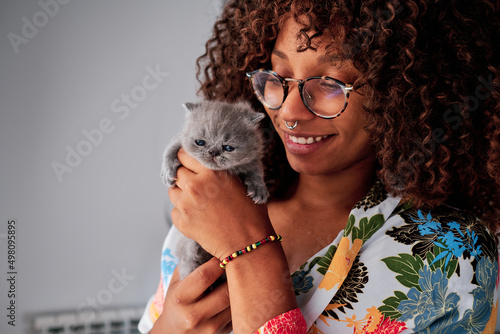 Canvas Print young black woman with curly hair with a little exotic grey cat