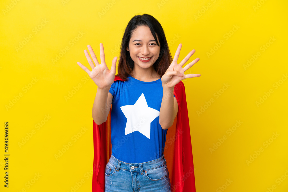 Super hero Vietnamese woman isolated on yellow background counting nine with fingers Super hero Vietnamese woman isolated on yellow background counting nine with fingers