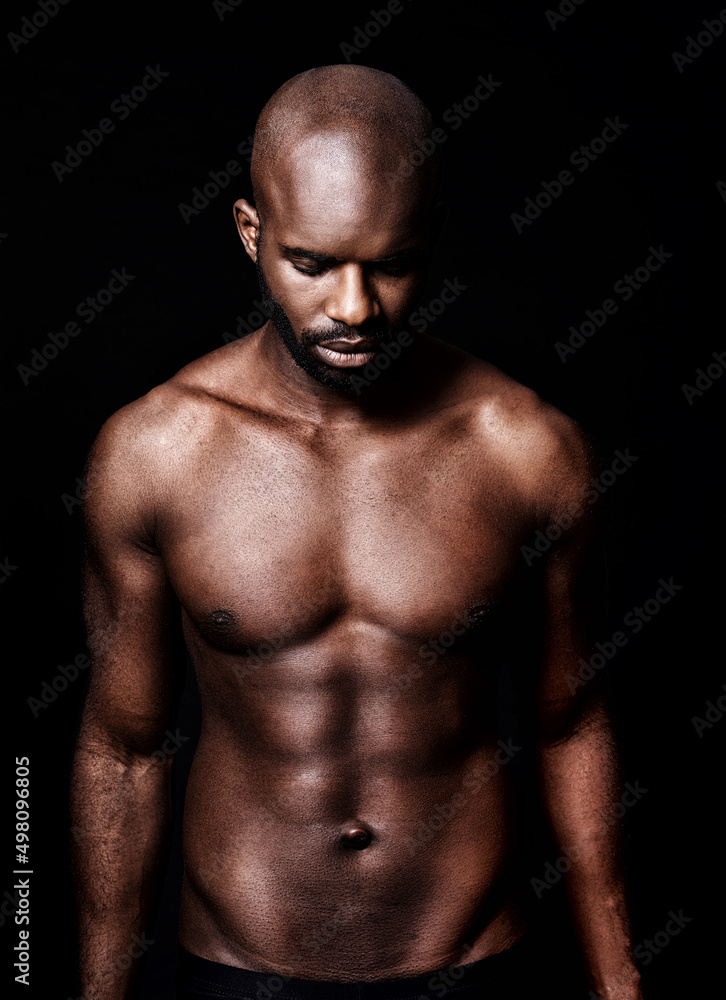 In a league of his own. Cropped shot of a calm muscular man isolated on black. In a league of his own. Cropped shot of a calm muscular man isolated on black.