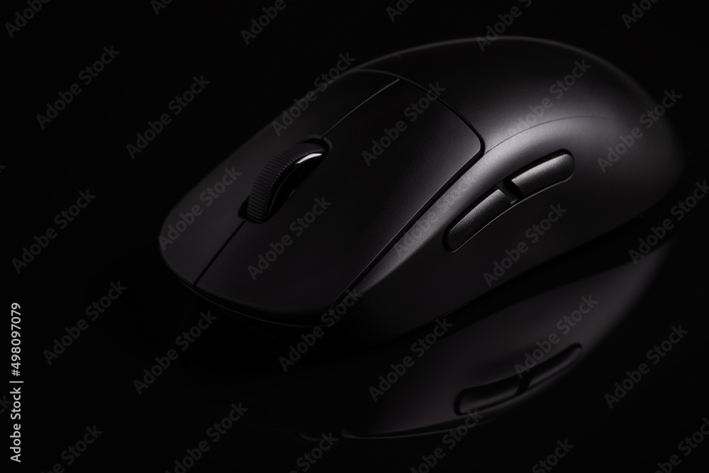 Black modern wireless computer mouse on black background Black modern wireless computer mouse on black background