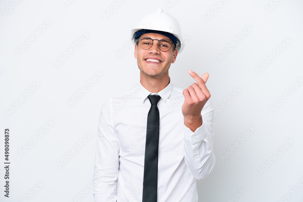 Young architect caucasian man with helmet and holding blueprints isolated on white background making money gesture Young architect caucasian man with helmet and holding blueprints isolated on white background making money gesture