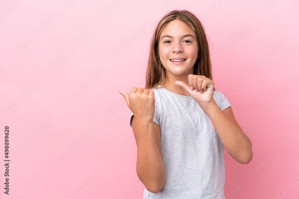 Little caucasian girl isolated on pink background pointing to the side to present a product Little caucasian girl isolated on pink background pointing to the side to present a product
